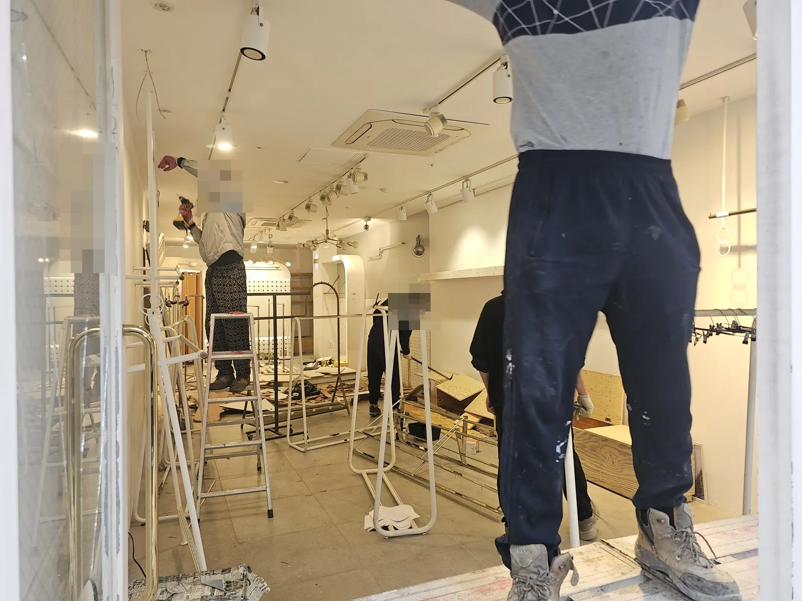 매장 안에서 행거와 집기를 해체하고 바닥에 합판 조각이 흩어져 있다