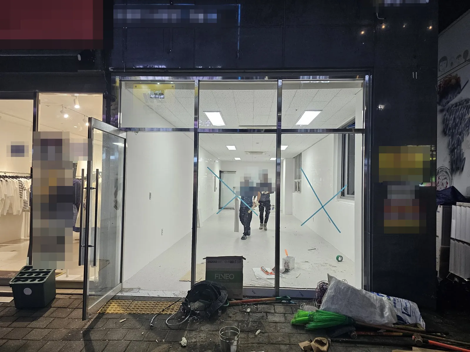철거 후 비워진 매장 내부 바닥과 벽이 정리되고 입구 앞에 공구가 놓여 있다