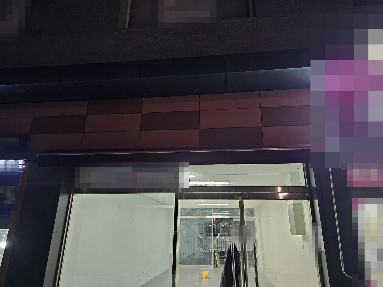 밤에 본 비워진 상가 전면과 유리 출입문 내부이다.