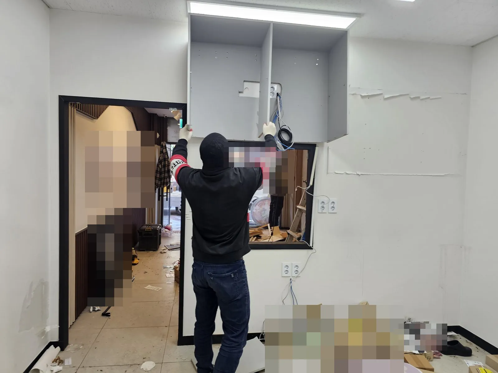 벽 상부 수납장을 떼어내는 설비 분리와 바닥에 쌓인 상자 잔재