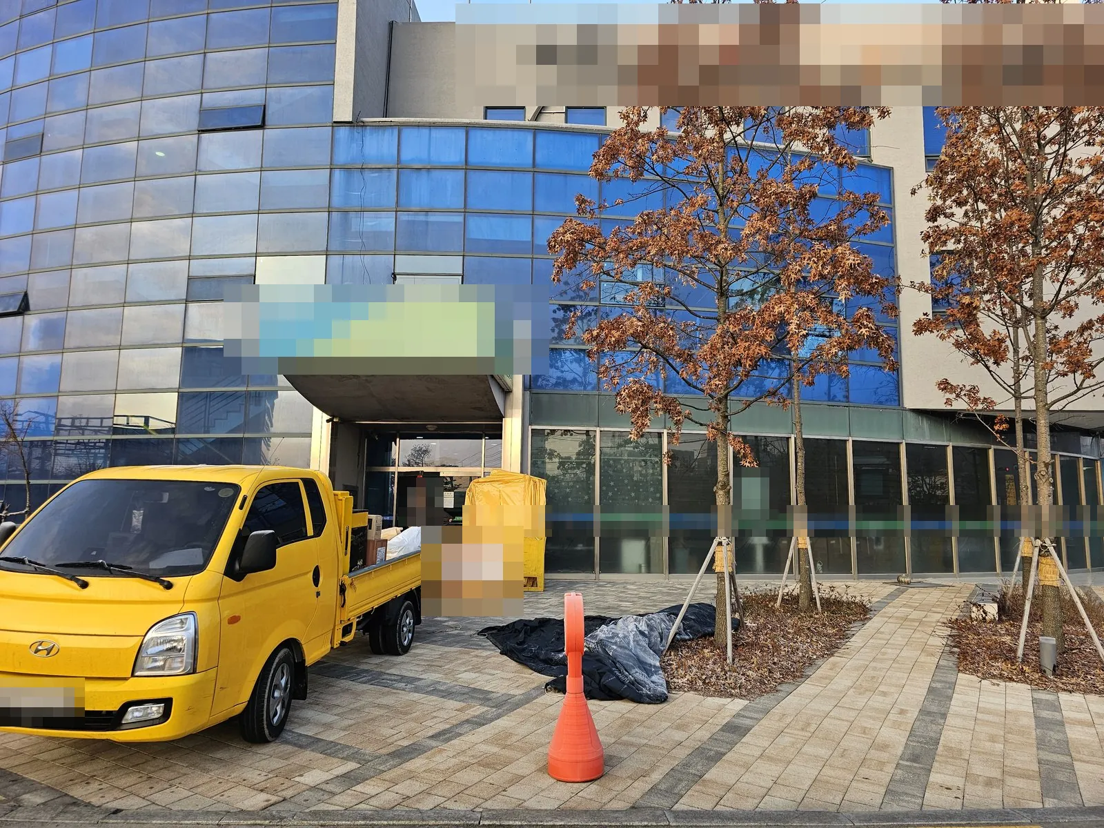 건물 출입구 앞 화물차에 집기를 싣고 있는 반출 작업