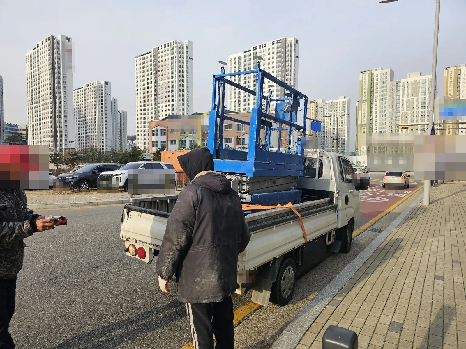 화물차에 고소작업차를 싣고 고정한 반출 준비 장면