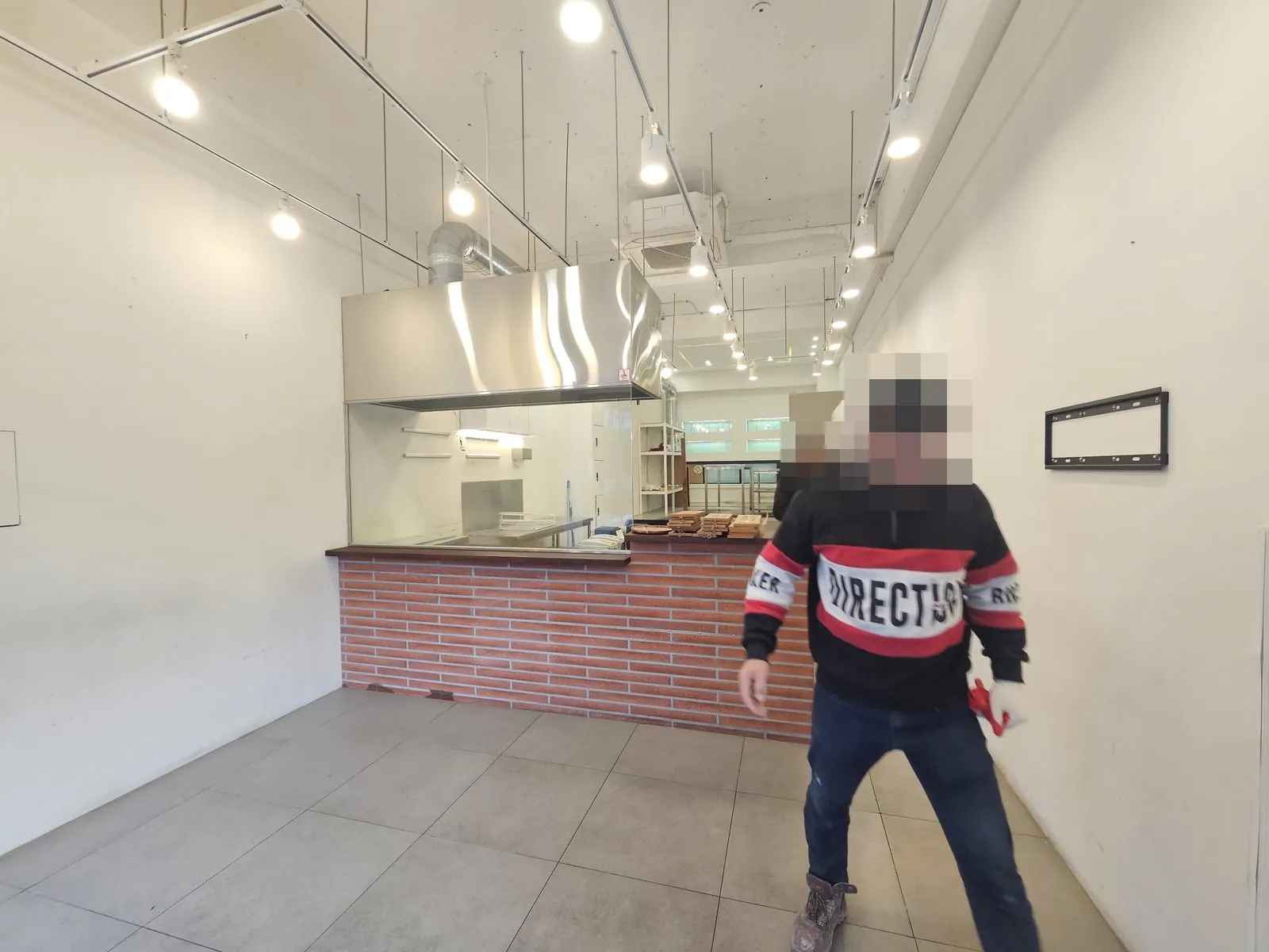 집기가 남은 매장 홀의 벽돌 카운터와 후드
