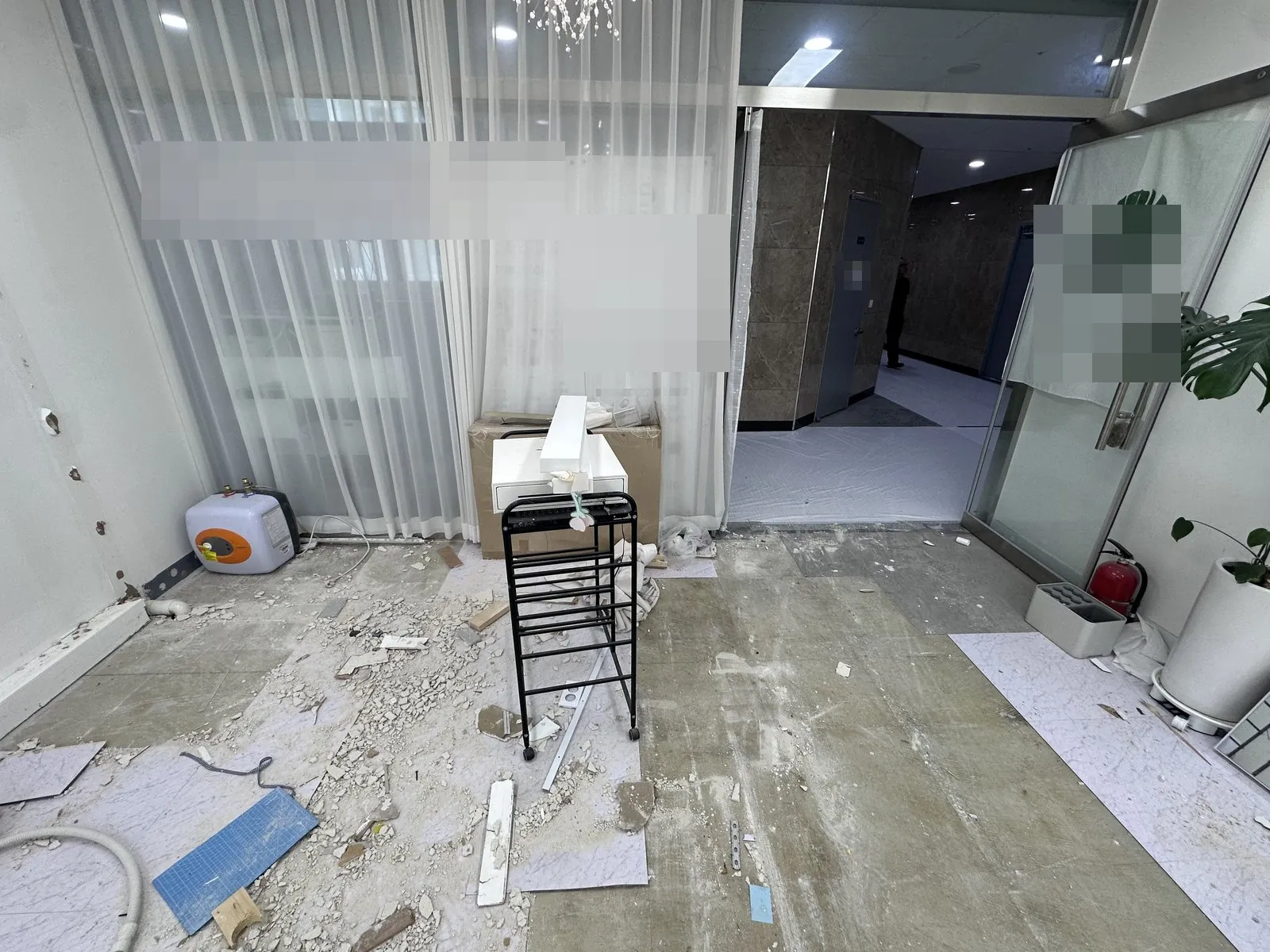 출입구 앞 바닥재가 뜯겨 잔재가 흩어진 매장 바닥