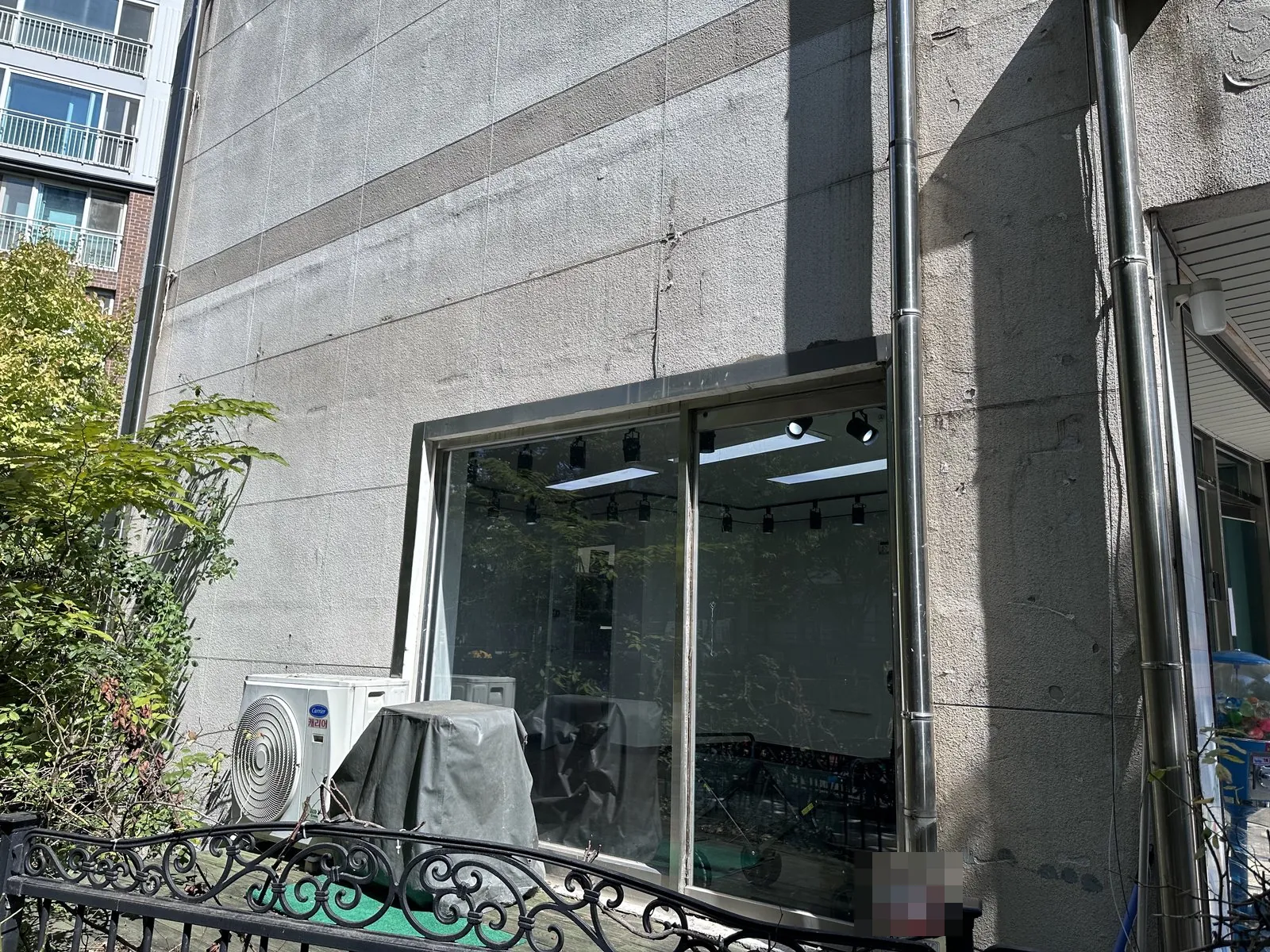 철거 전 매장 건물 외벽과 유리 창호, 실외기가 보인다.