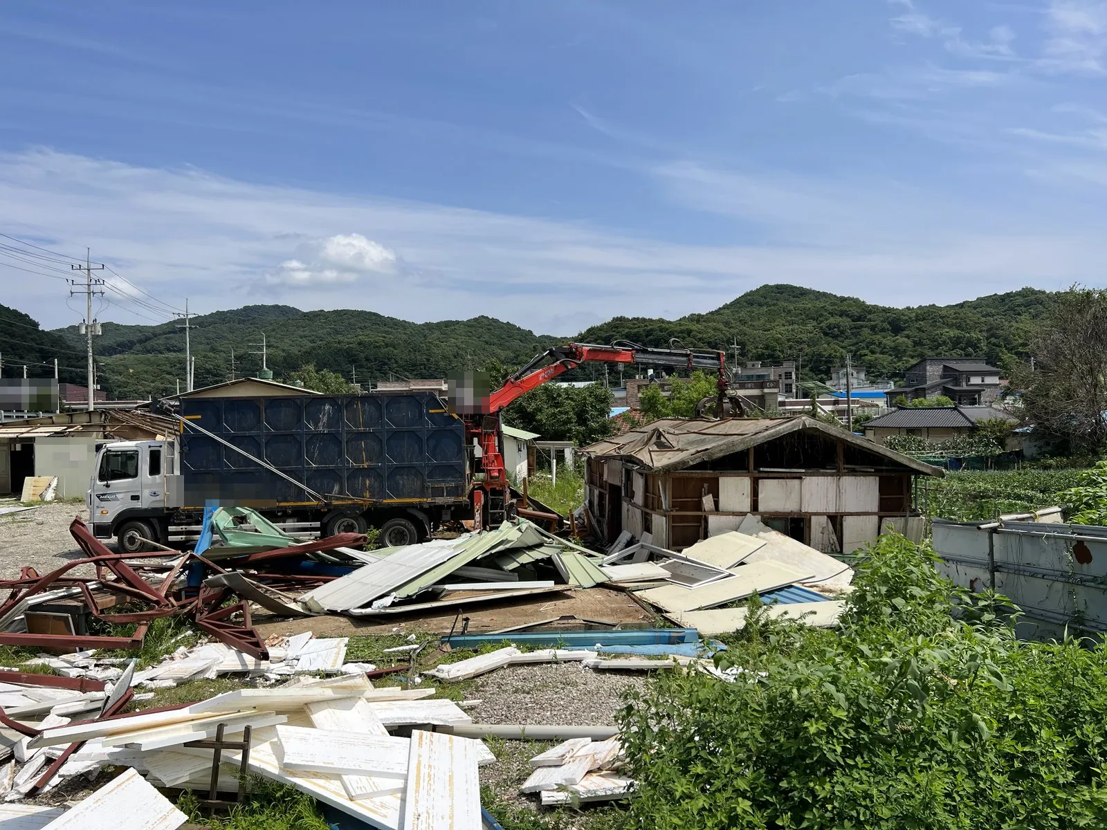 크레인 차량으로 해체된 패널과 철골 잔재를 싣는 현장