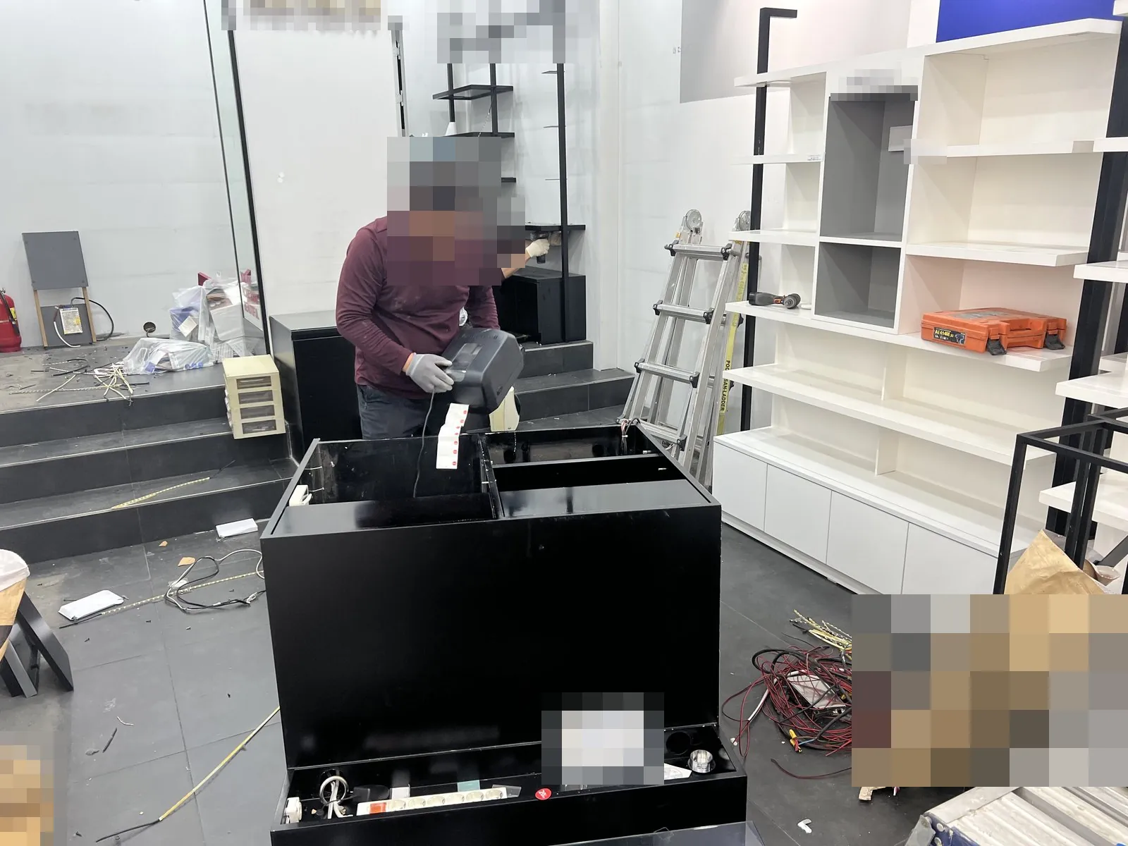 매장 홀에서 계산대 집기를 분리하는 작업, 전선과 사다리가 보임