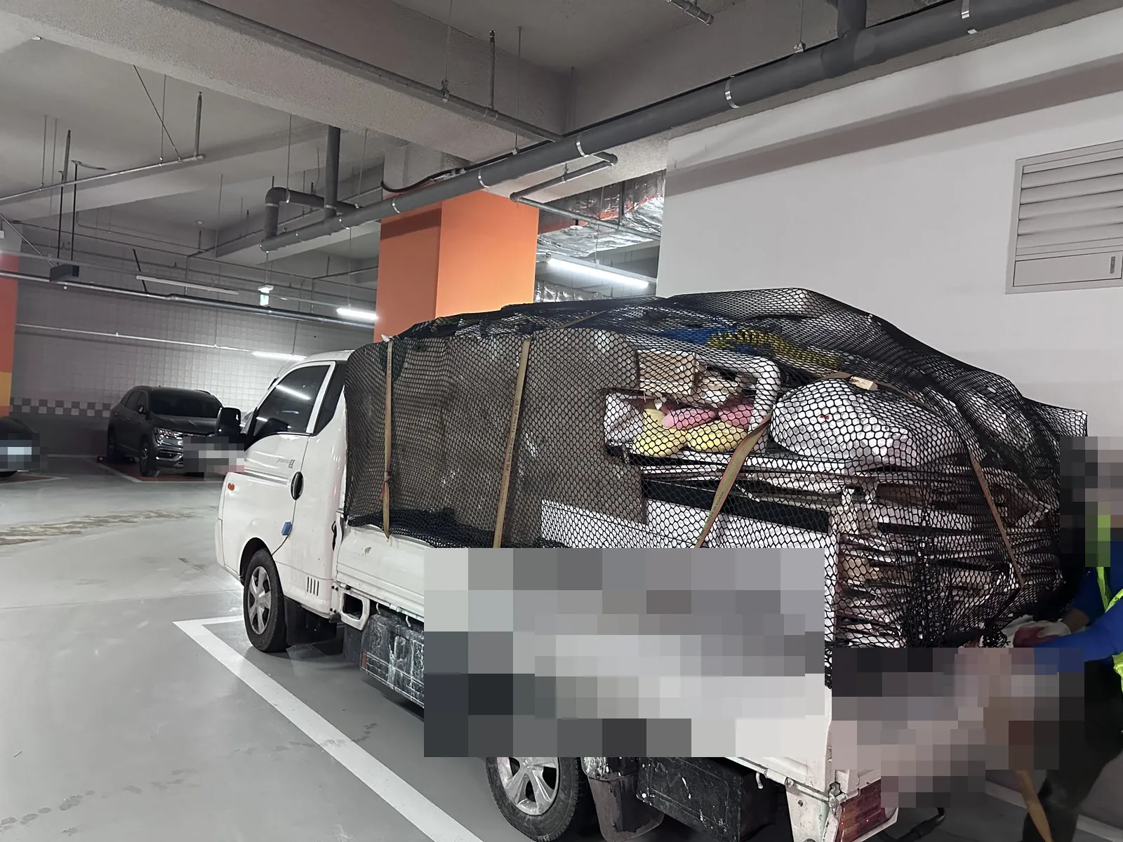 지하주차장에서 잔재를 그물로 덮어 화물차에 싣고 고정함