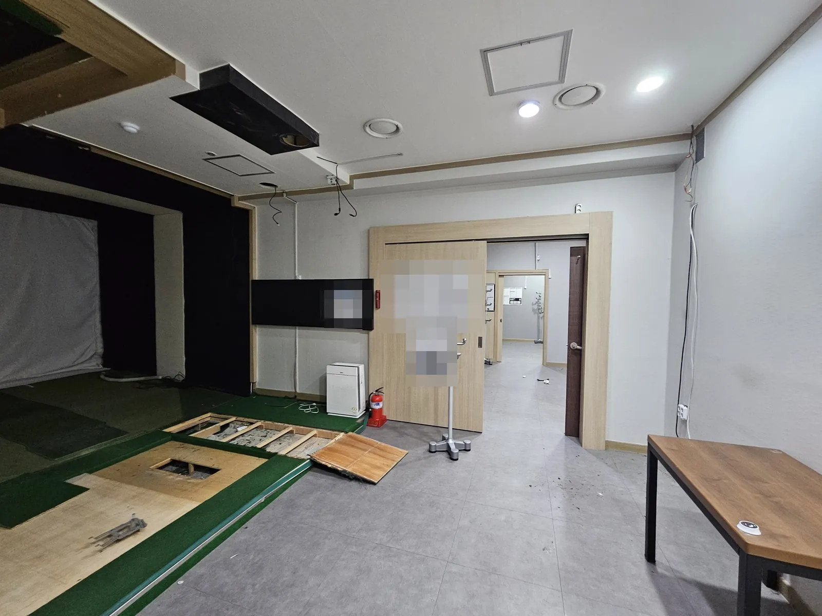 실내 바닥 패널이 일부 뜯겨 합판과 하부 목틀이 드러남
