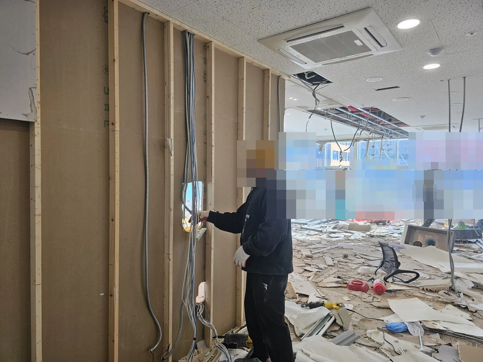 석고보드 벽체 해체 후 목재 골조와 배선이 드러난 실내 철거 현장