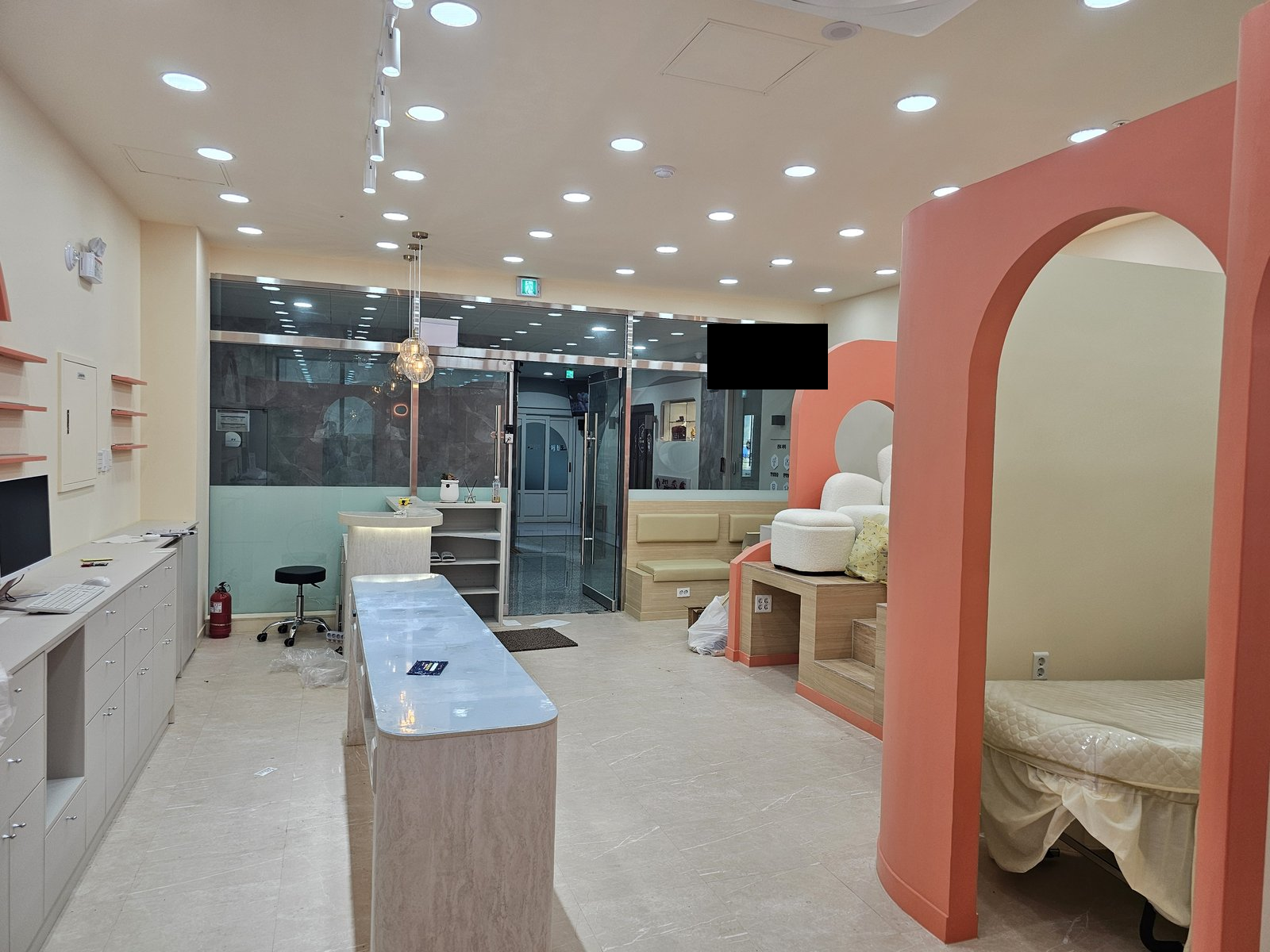 조명과 카운터, 수납장, 유리 칸막이, 아치형 구조물이 있는 실내 공간 기존 검은 가림이 유리 벽 위쪽에 있음 사진에 보이지 않는 범위나 과거 작업 이력은 확인하지 않았습니다.