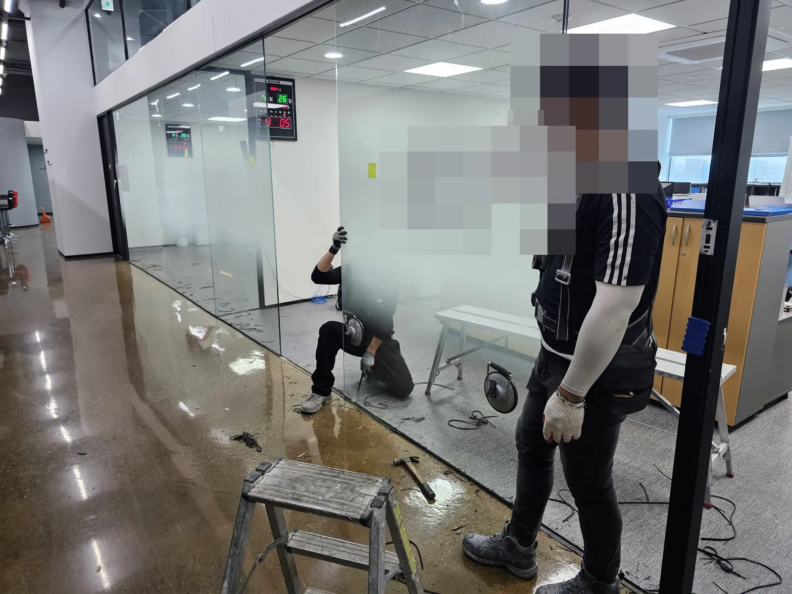 사무 공간 유리 칸막이를 해체하는 작업과 바닥의 잔재