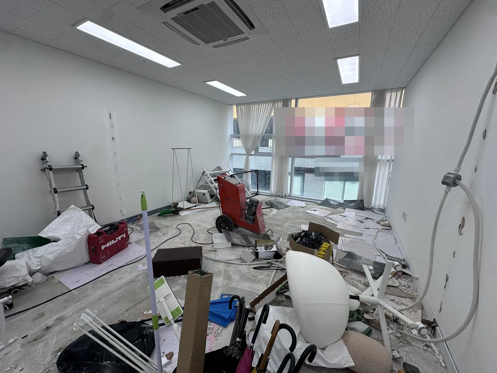 바닥재를 걷어낸 실내에 장비와 집기·마대가 놓임