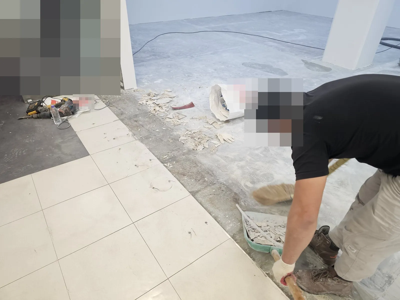 철거한 바닥의 잔재를 빗자루로 쓸어 담는 작업