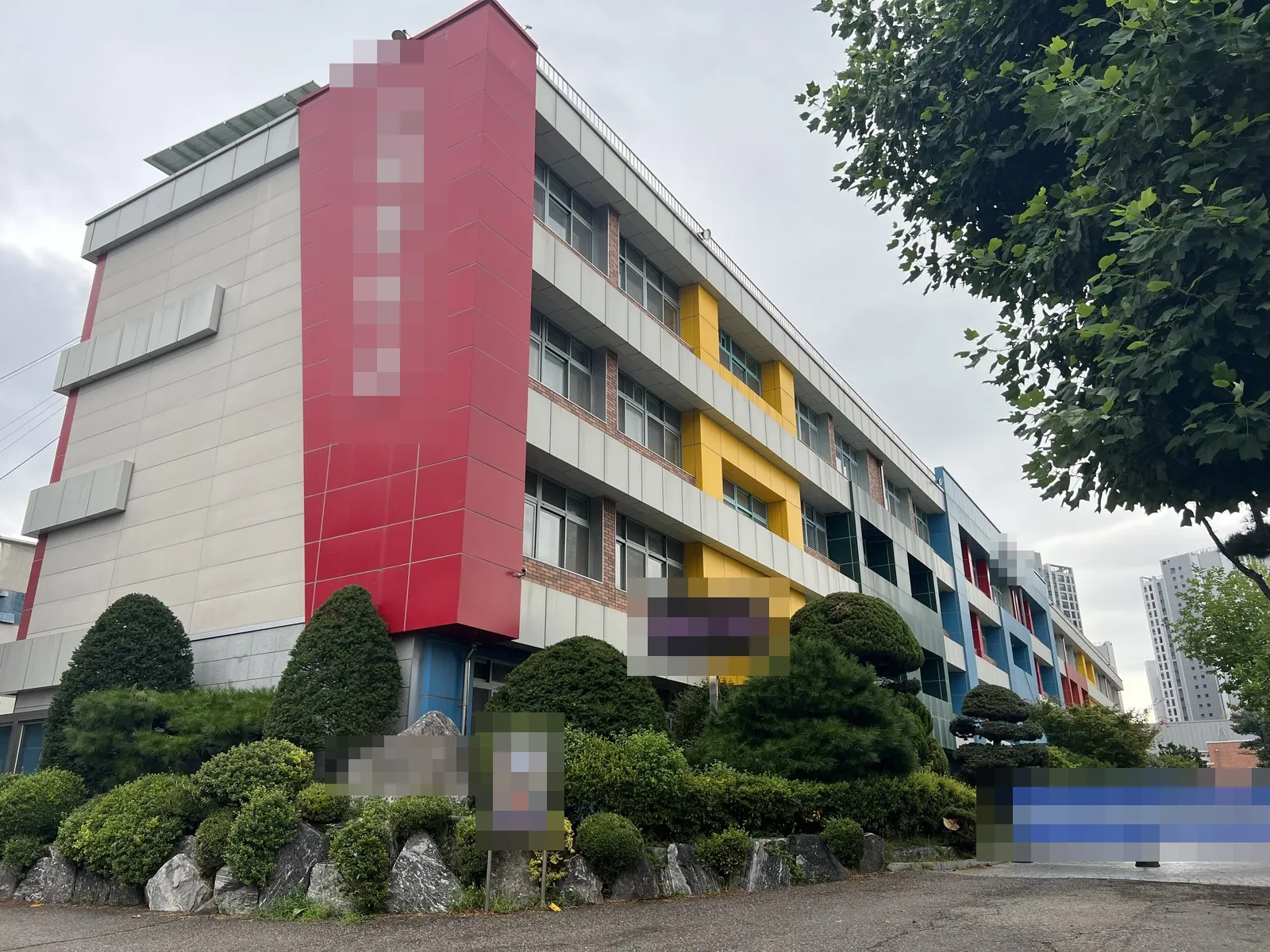 학교 건물 외벽과 정문 앞 안전 가림막이 보인다.