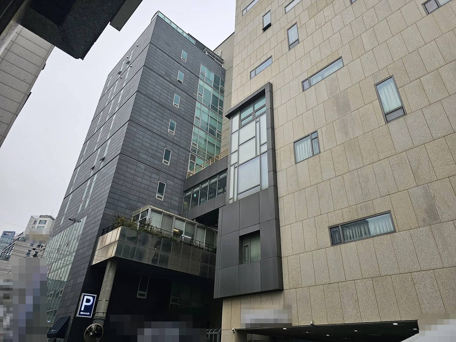 작업 건물 외관, 석재 마감 외벽과 유리창이 보이는 저층부