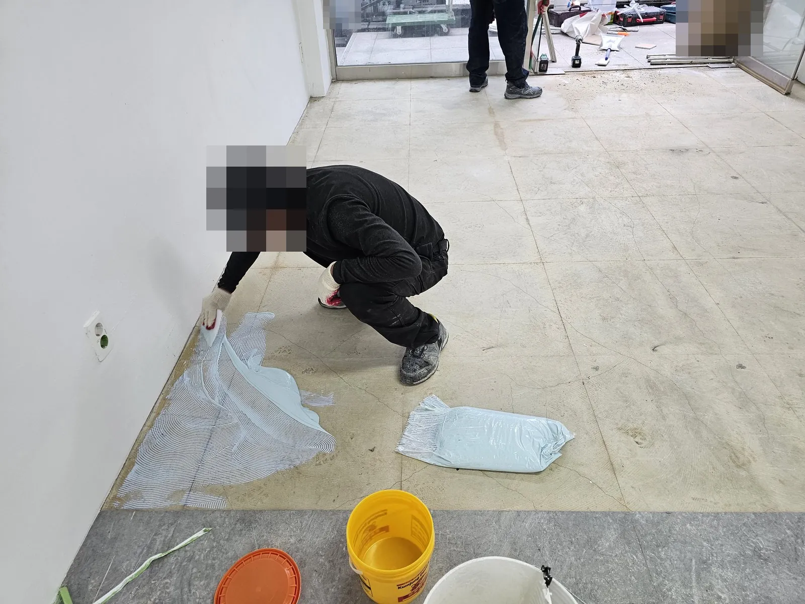 바닥재를 걷어낸 매장 바닥에 접착제를 바르는 작업이다.