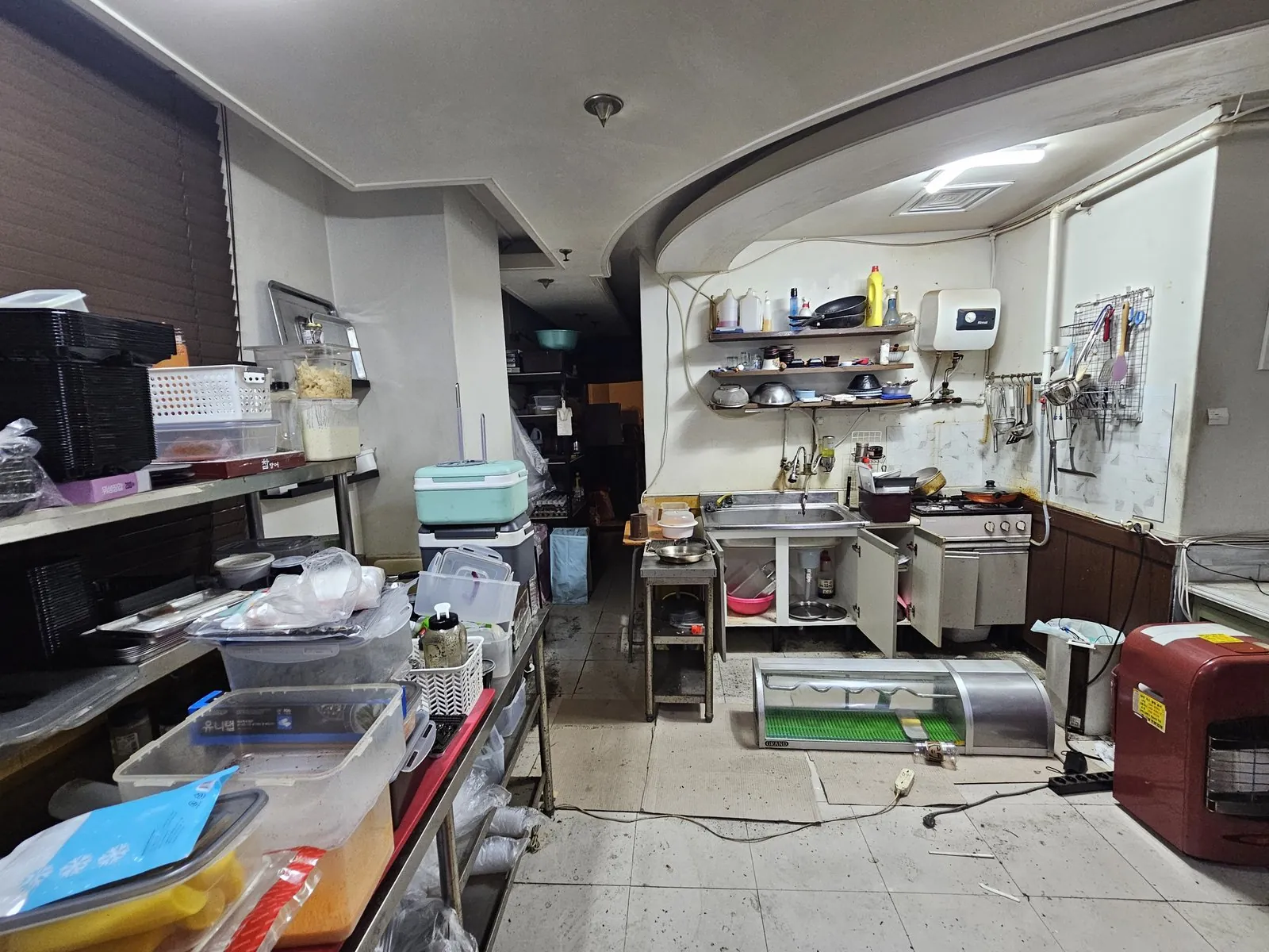 주방에 선반과 용기, 싱크대, 초밥 진열장 등 집기가 그대로 남아 있음
