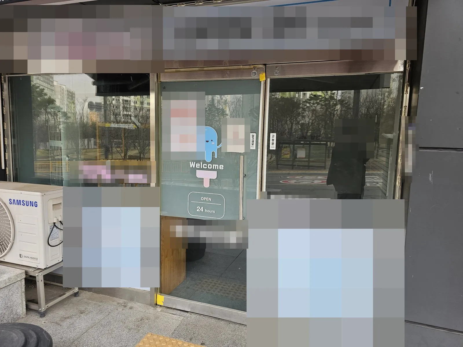 철거 전 폐업한 상가 유리 출입문과 실외기가 보인다.
